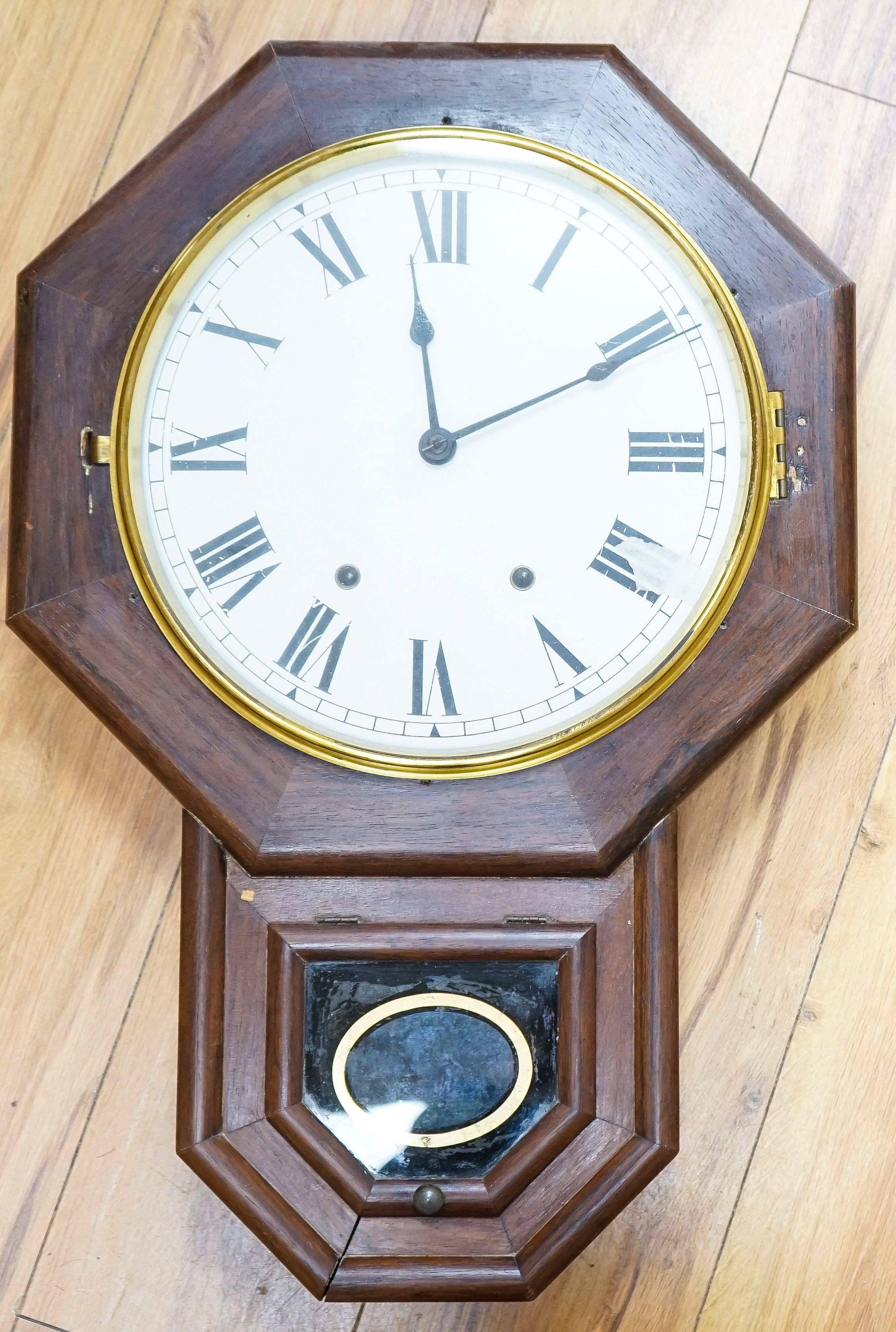 A mahogany octagonal dial clock with key and pendulum 60cm